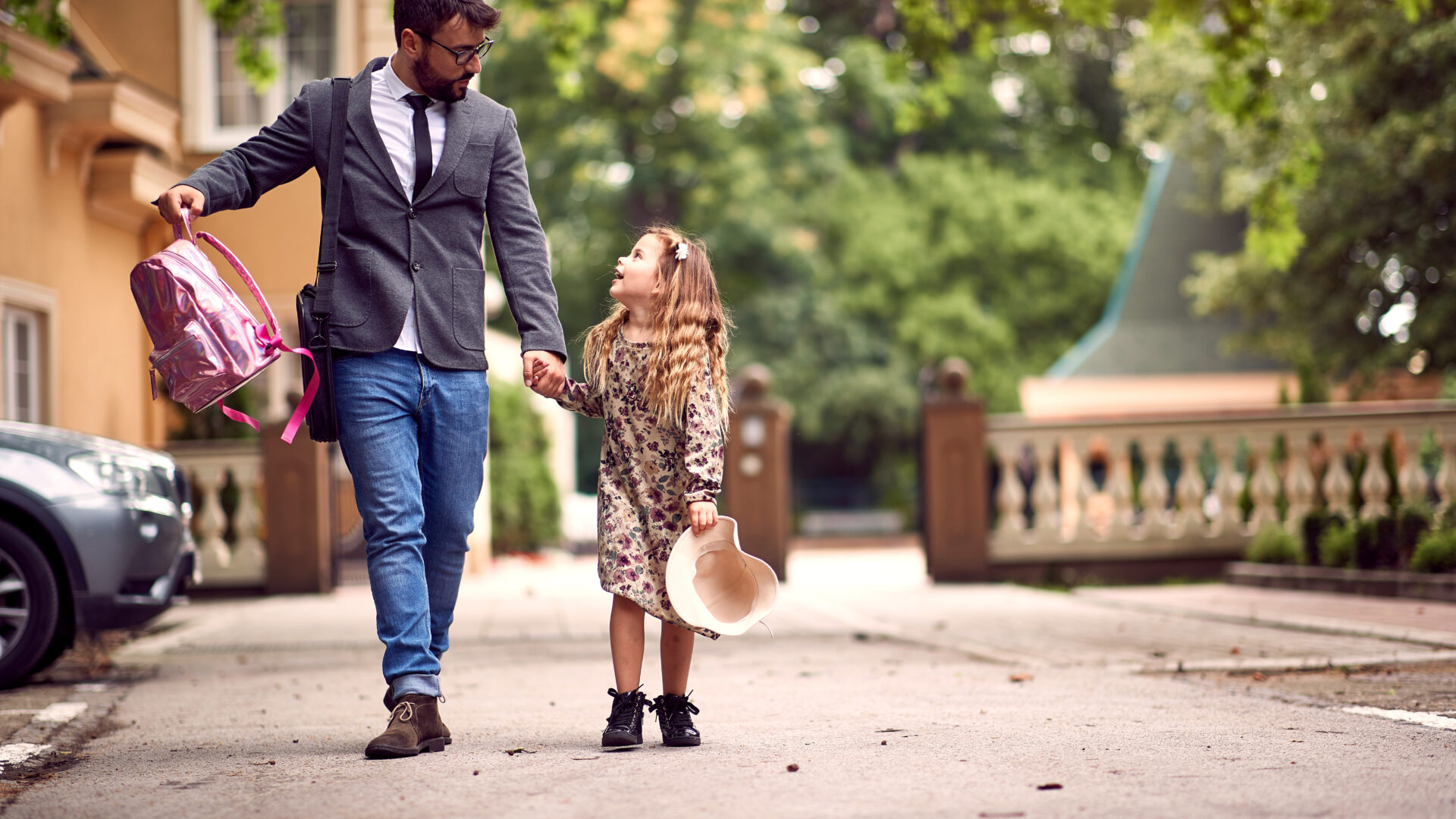 father and child holding hands going to school